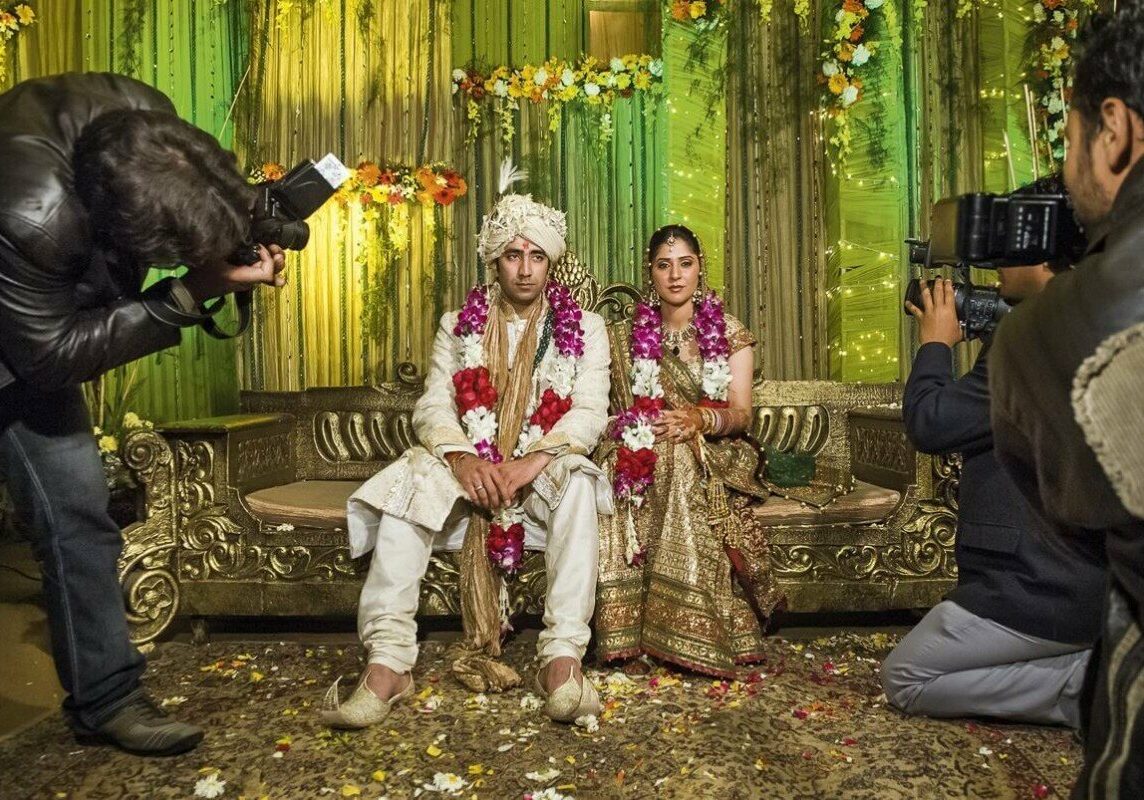 The couple are seated together on an elevated platform and the traditional photographers take their first picture together before the wedding. After a minute or two even the most patient couple could be tired of posing. Punjabi wedding in Delhi, 2008